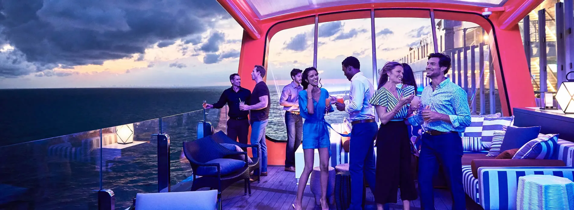 Friends enjoying cocktails on a cruise ship deck at sunset