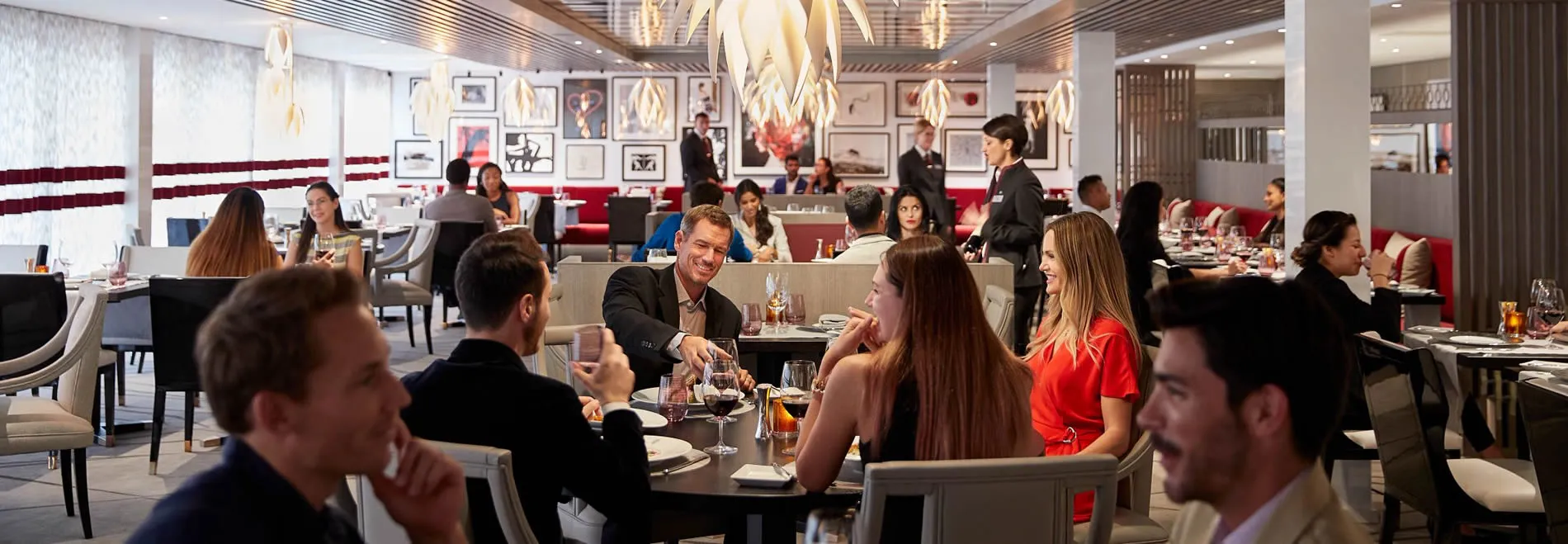 Busy upscale restaurant with people dining and staff serving tables