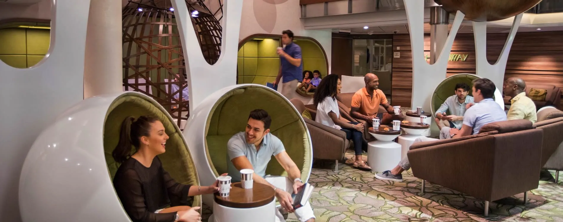 Modern office lounge with people relaxing in egg-shaped chairs and conversation areas