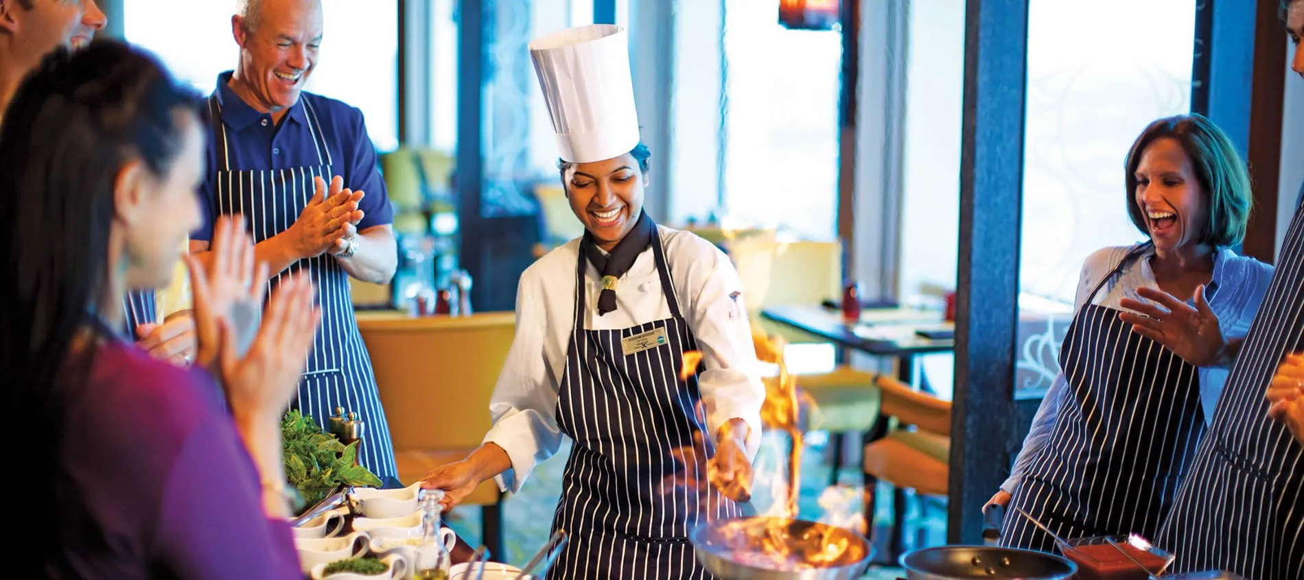 Chefs in striped aprons cooking with flames and excitement in restaurant