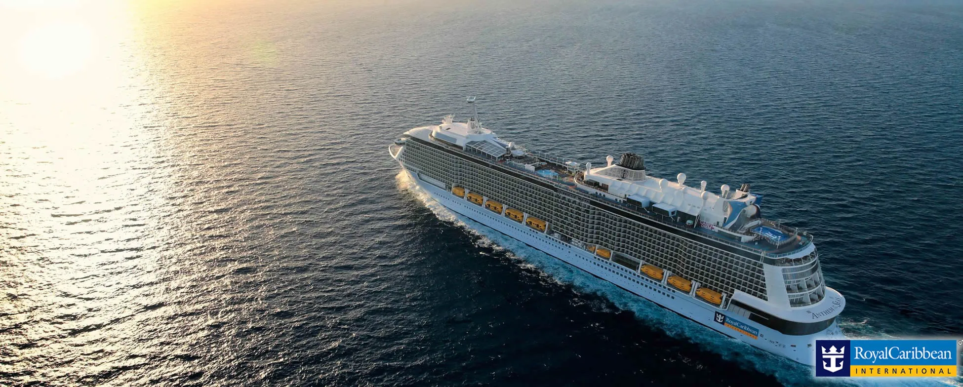 Large Royal Caribbean cruise ship sailing on calm ocean at sunset