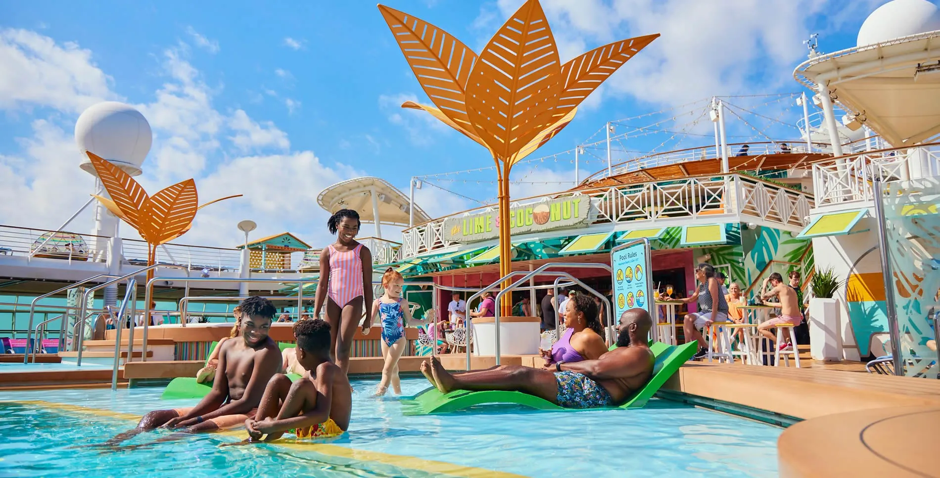 Colorful cruise ship pool deck with orange leaf-shaped shade structures
