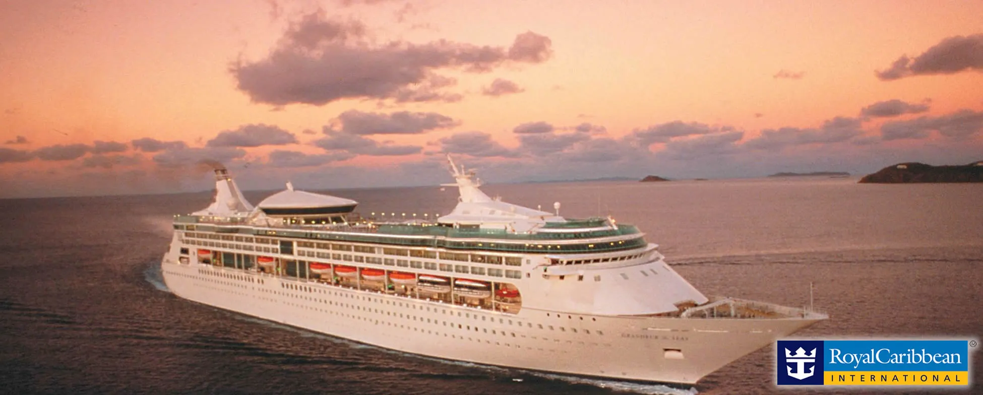 Large white Royal Caribbean cruise ship sailing at sunset near tropical islands