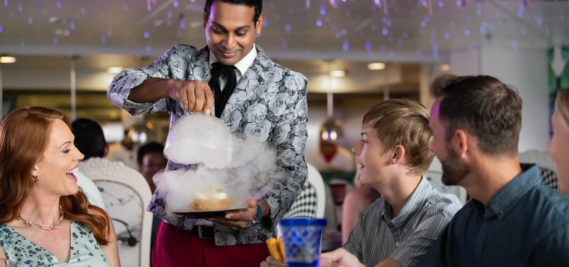 Magician in floral vest performs smoking dessert trick for amazed audience