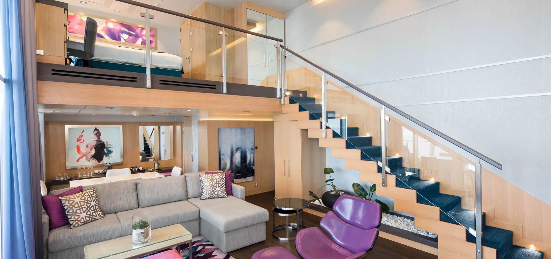 Modern loft-style hotel room with mezzanine, stairs, and purple accents
