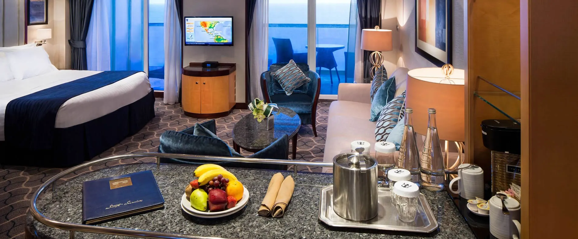 Luxurious cruise ship cabin with ocean view, fruit plate, and coffee service