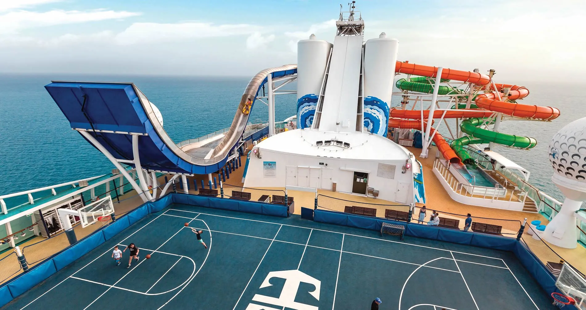 Cruise ship deck with basketball court and colorful water slides