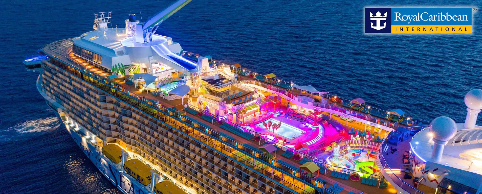 Royal Caribbean cruise ship illuminated at night with colorful decks