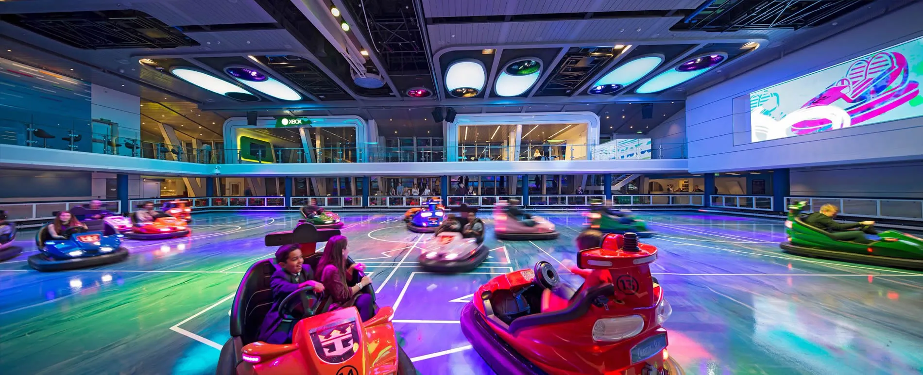 Colorful bumper cars on illuminated floor in modern entertainment center