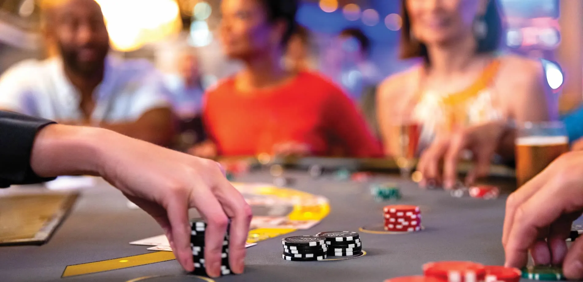 Casino gambling table with poker chips and blurred players in background