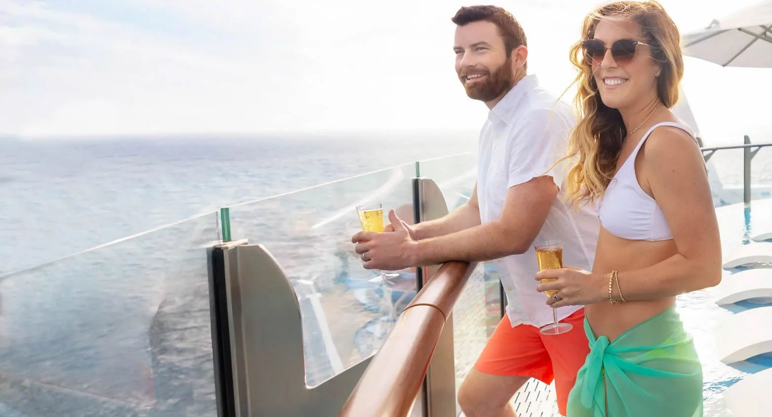 Couple enjoying drinks on cruise ship deck with ocean view