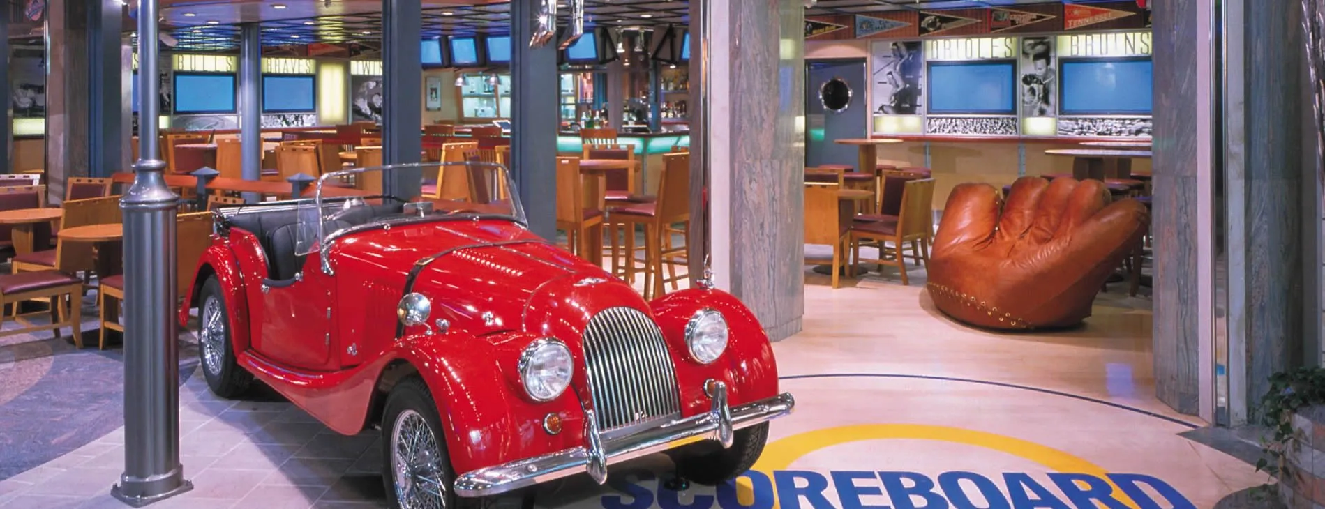 Bright red vintage sports car displayed in a modern cafe interior