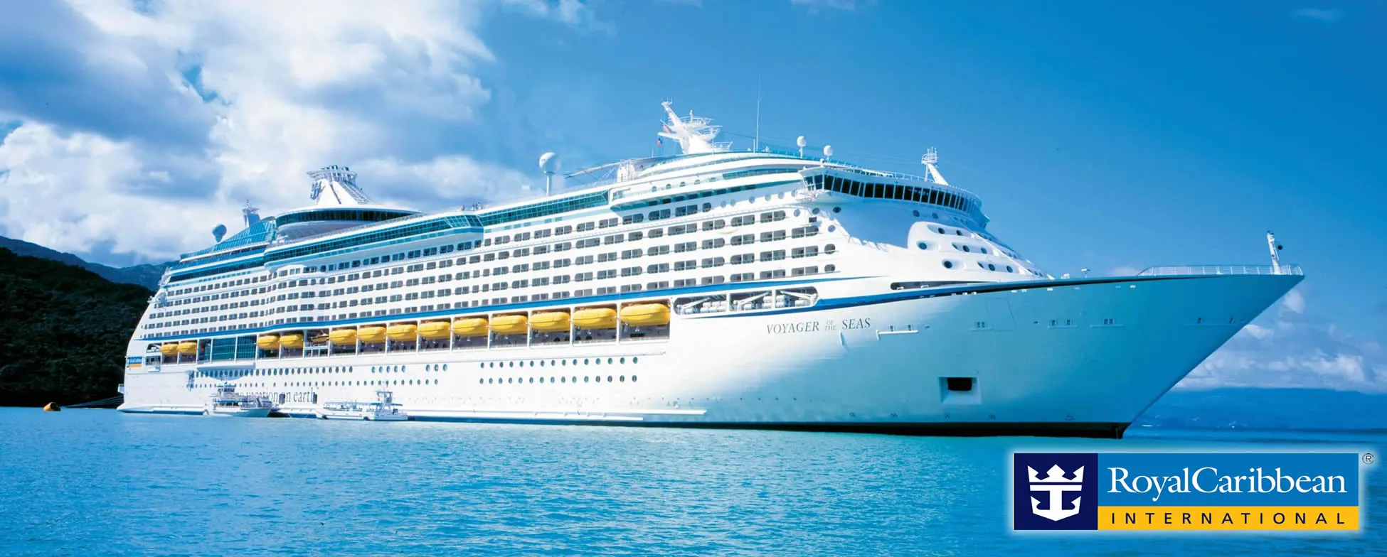 Large white Royal Caribbean cruise ship on blue ocean with mountains