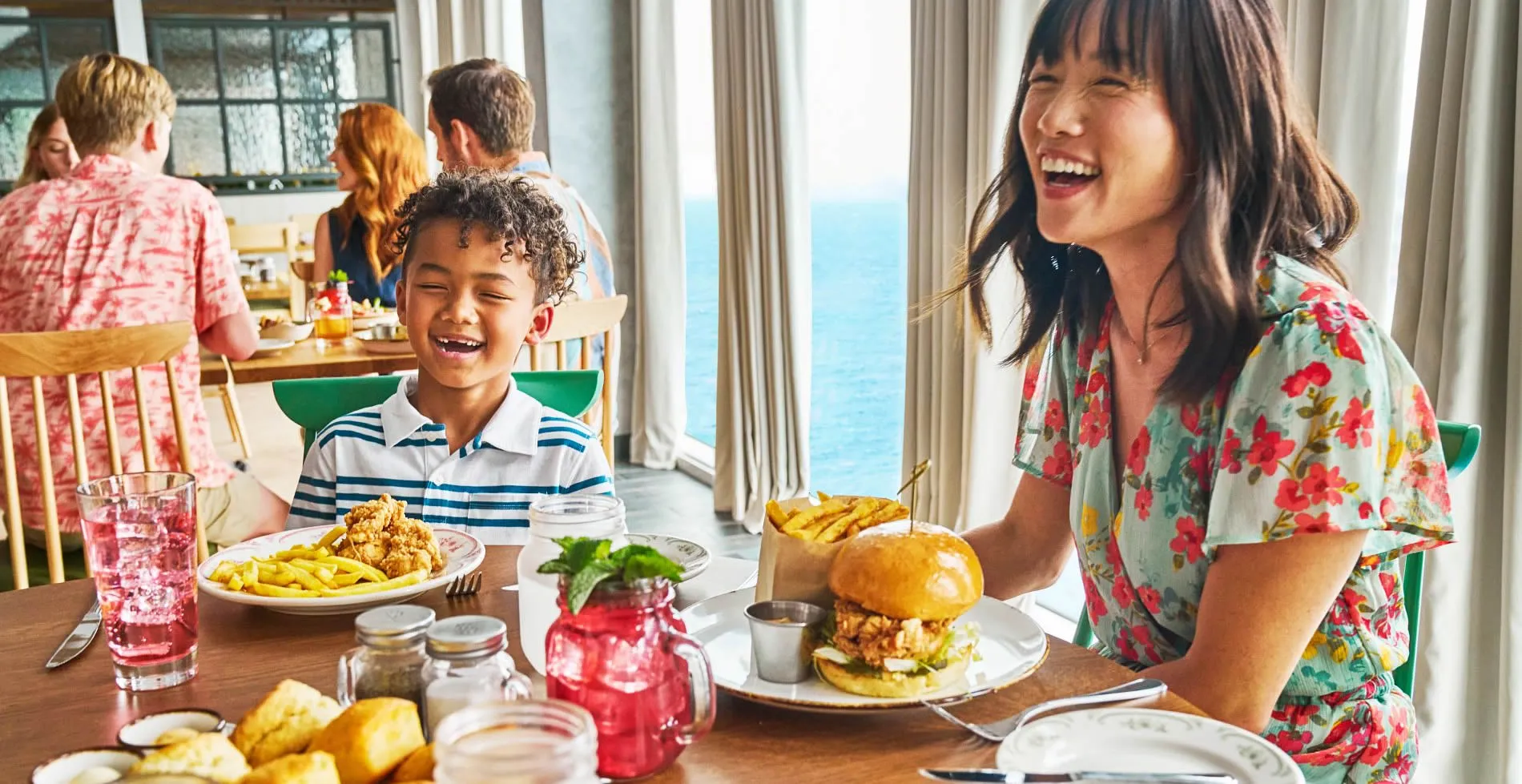 Joyful family enjoying a meal together with ocean view in background