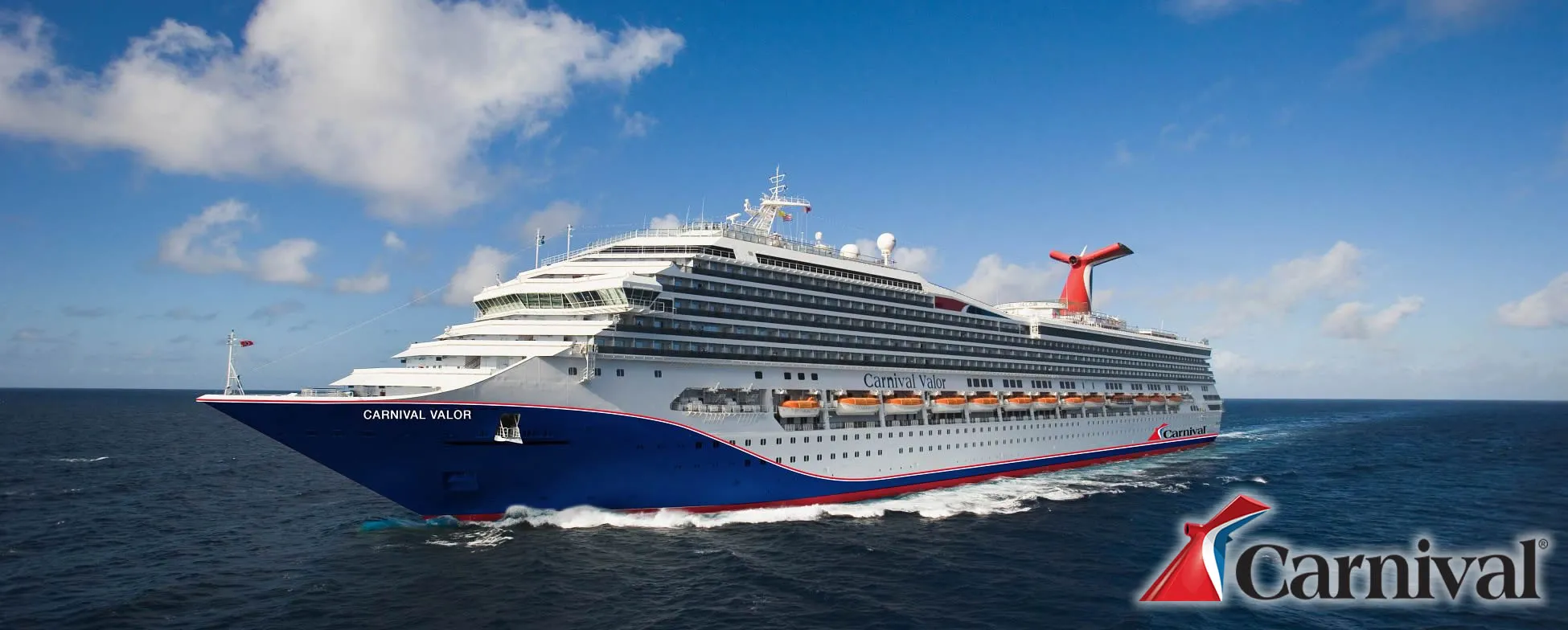 Carnival Valor cruise ship sailing on blue ocean under white clouds
