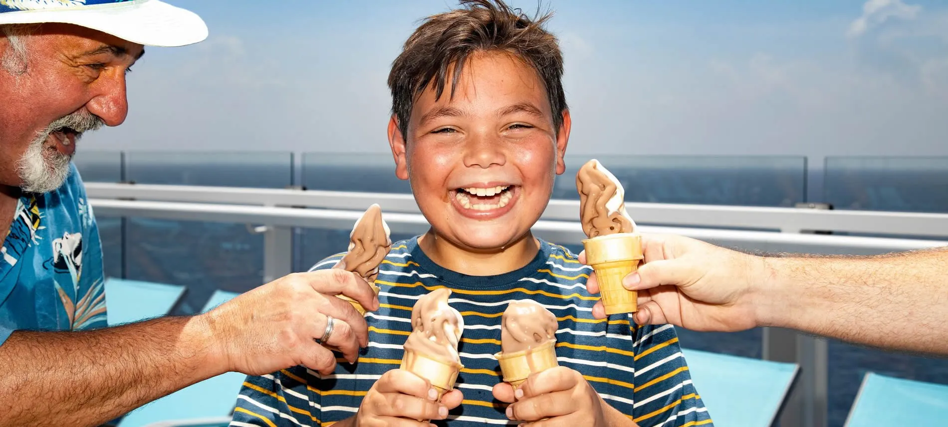 Joyful child holding three ice cream cones on a sunny day