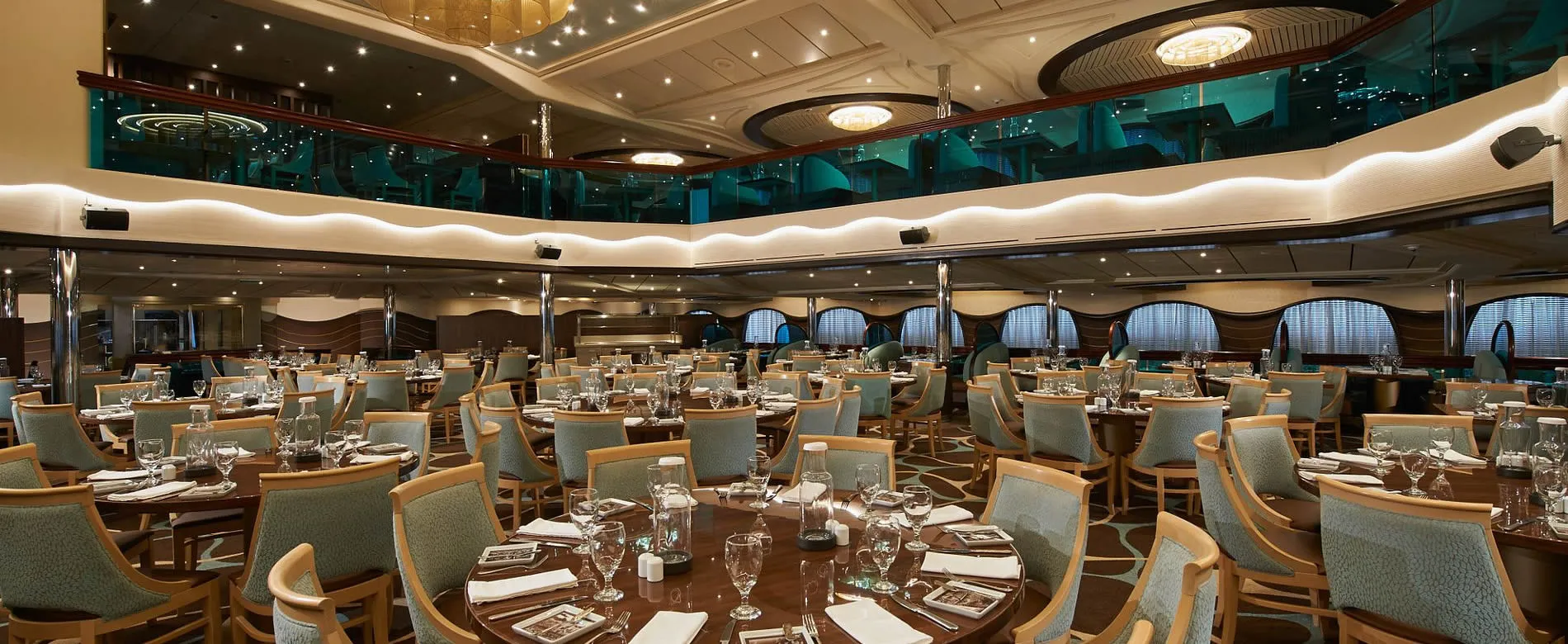 Elegant cruise ship dining room with turquoise chairs and crystal glassware