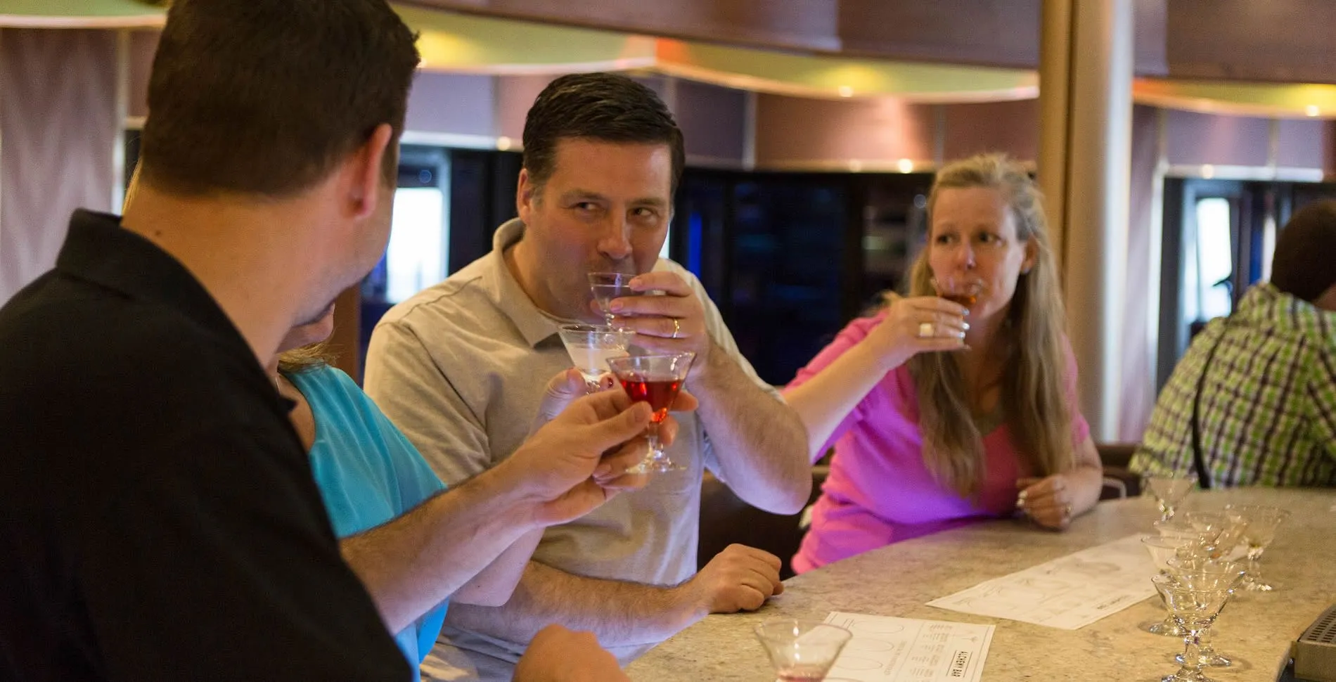 People enjoying cocktails together at a bar or restaurant counter