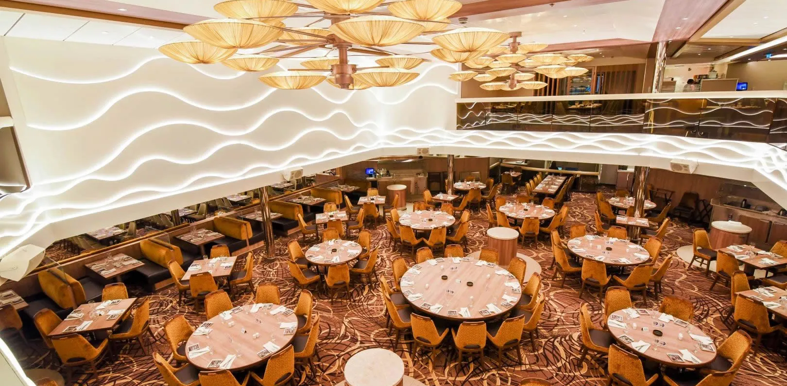 Elegant restaurant interior with round tables, yellow chairs, and umbrella-like ceiling lights
