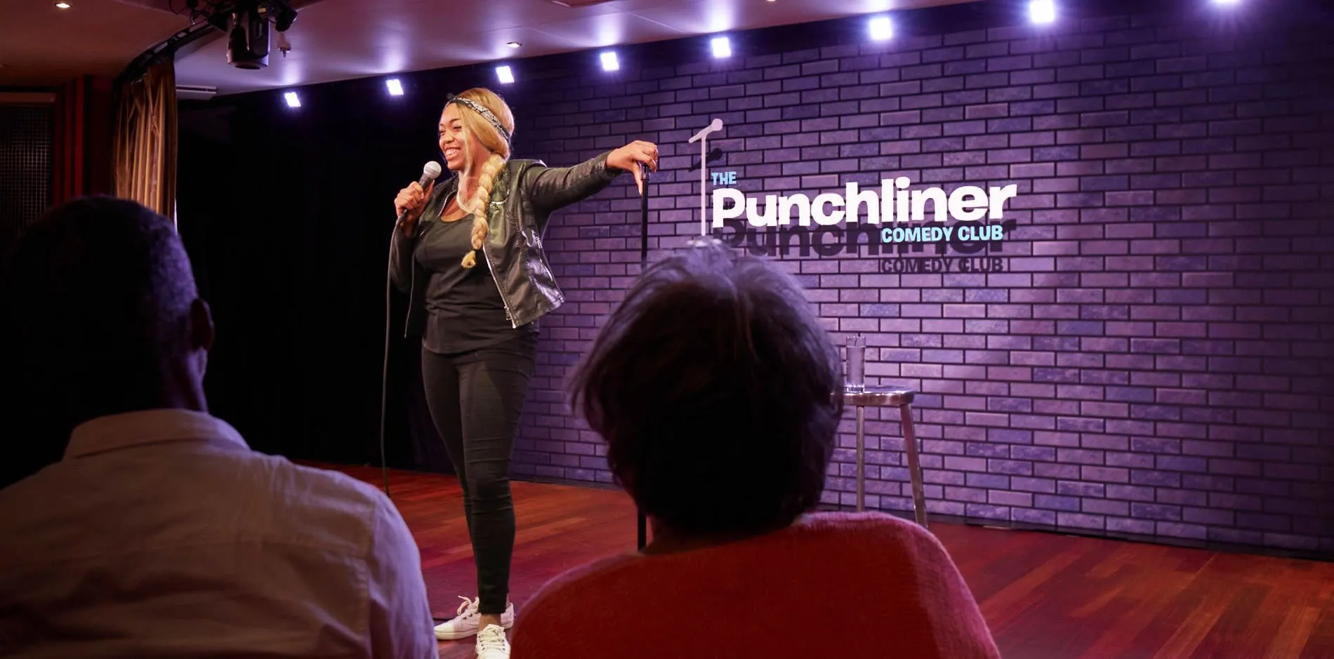 Comedian performing stand-up at Punchliner Comedy Club with audience in foreground