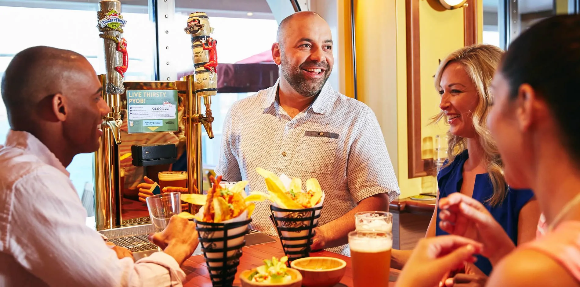 Friends enjoying drinks and food at a brewery with smiling bartender