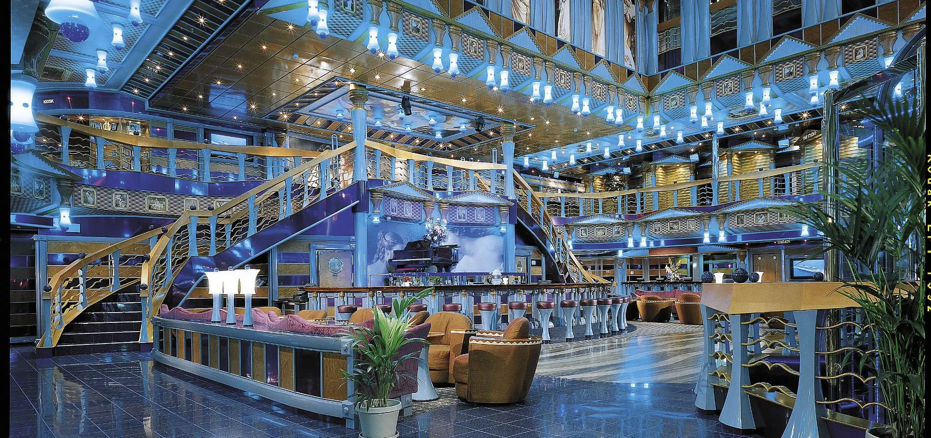 Luxurious multi-level lounge with blue lighting, bar, and elegant seating