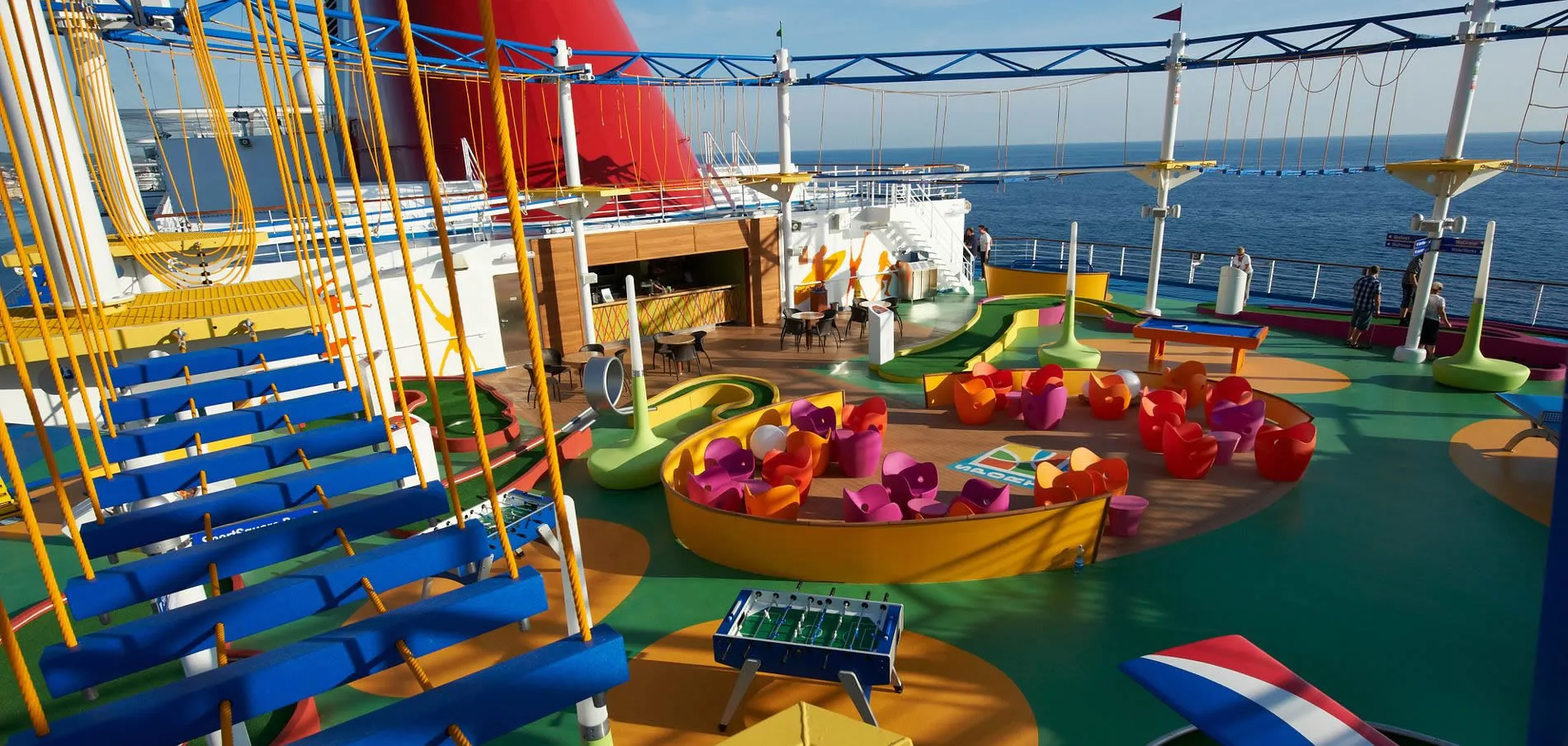 Colorful cruise ship deck with mini-golf, lounge chairs, and ocean view