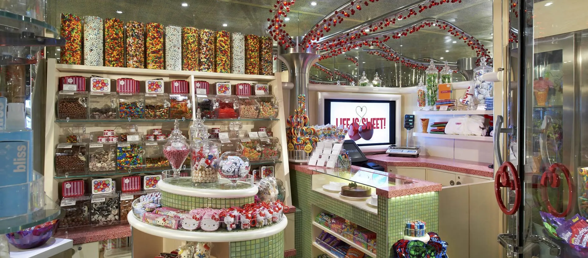 Colorful candy store with tall dispensers, jars, and shelves of sweets