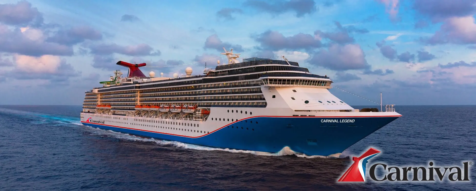 Carnival Legend cruise ship sailing on blue ocean with cloudy sky