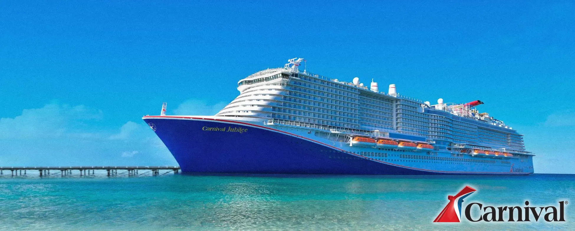 Large blue Carnival Jubilee cruise ship docked near pier in tropical waters