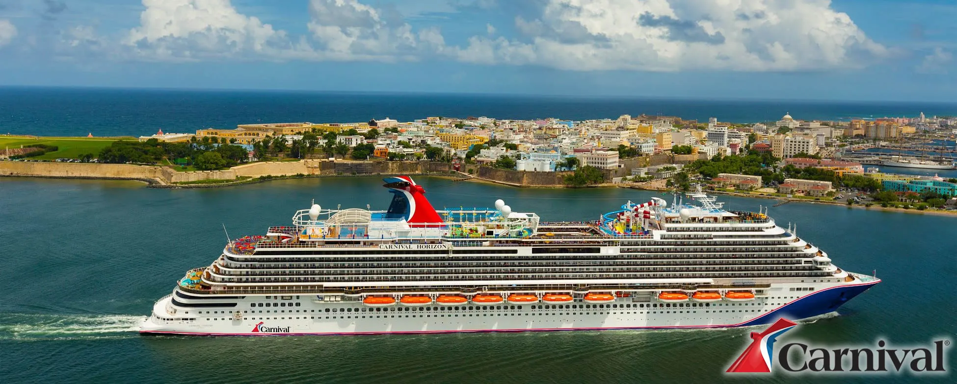 Carnival Horizon cruise ship docked in colorful coastal city with blue sky