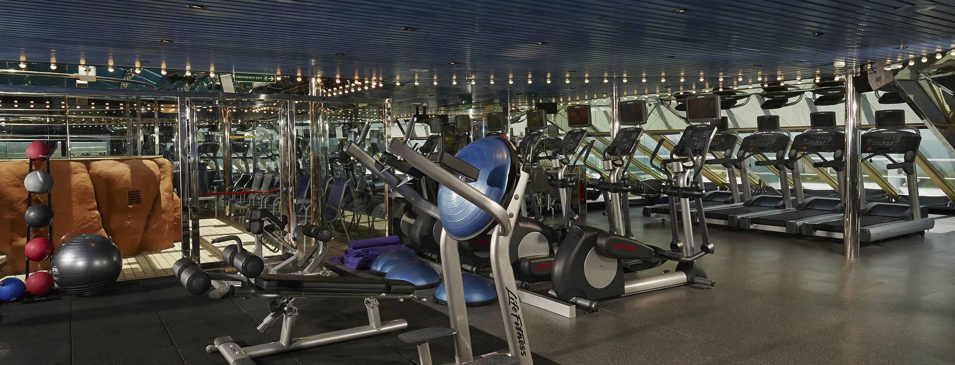 Modern gym interior with exercise equipment, treadmills, and exercise balls
