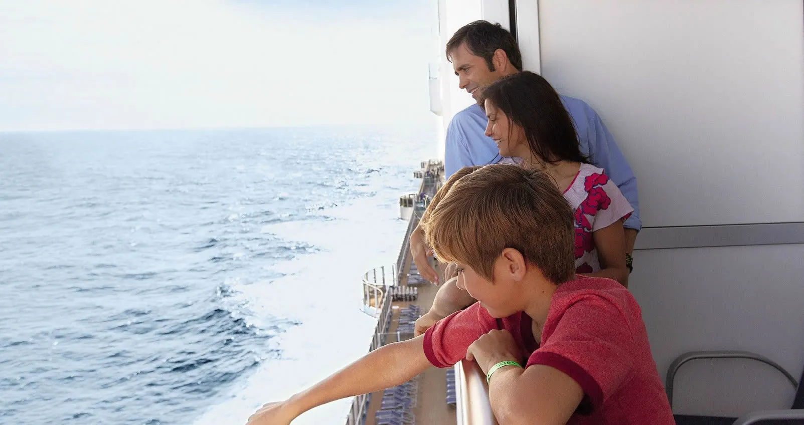 Family looking out over ocean from cruise ship deck