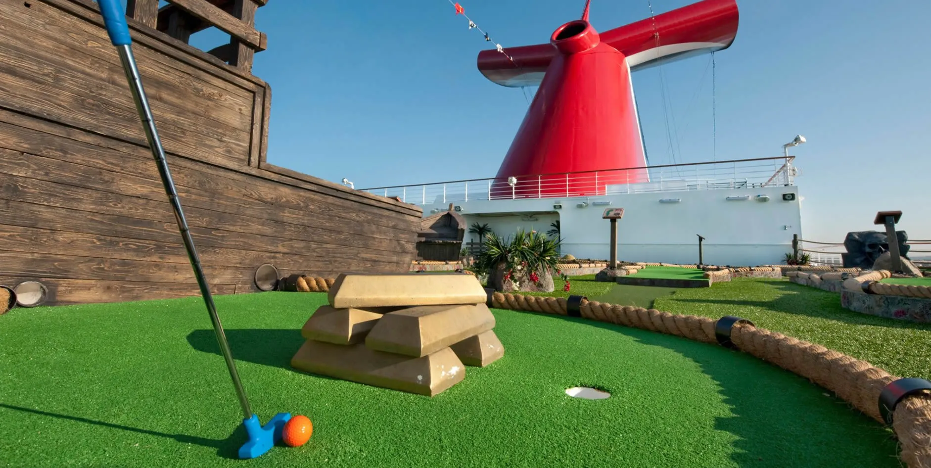 Miniature golf course on cruise ship deck with red funnel