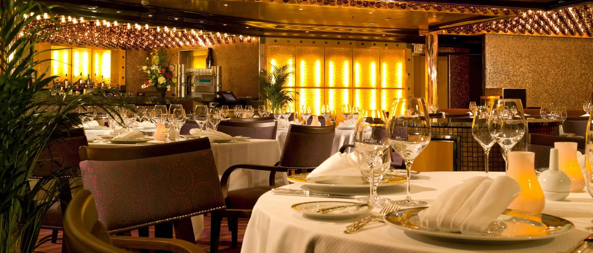 Elegant restaurant interior with white tablecloths, glassware, and warm lighting