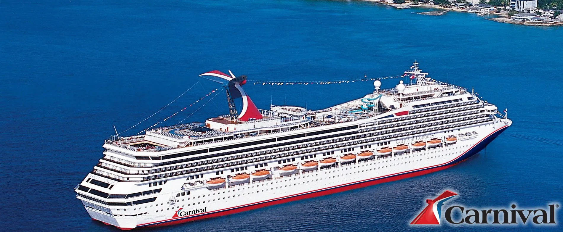 Carnival cruise ship sailing on blue ocean with coastal landscape