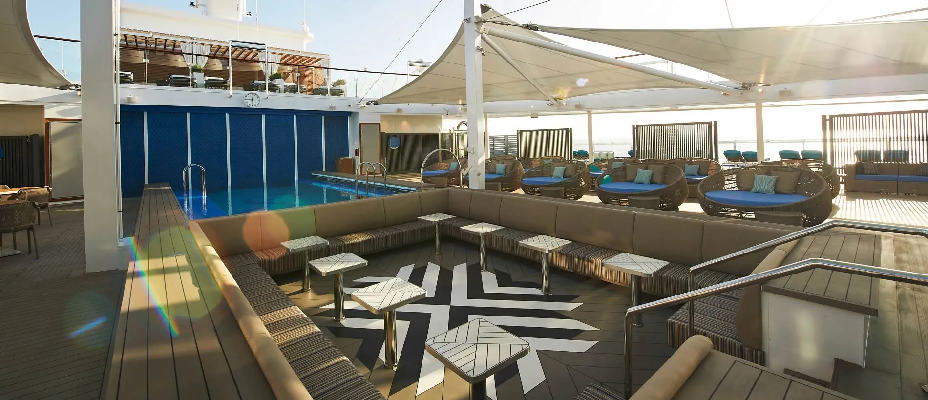 Luxurious cruise ship deck with pool, lounge seating, and modern design