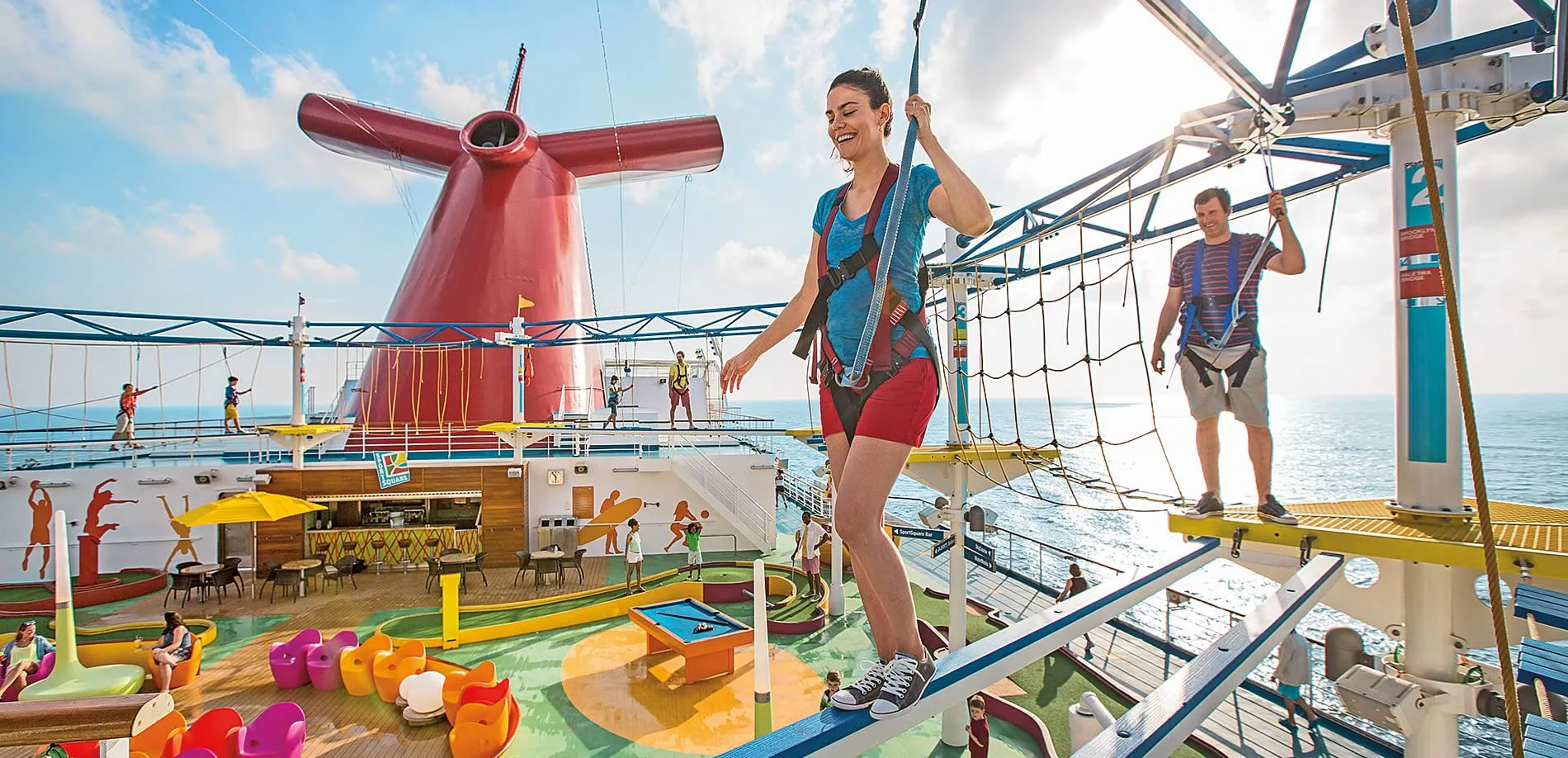 Cruise ship deck with people enjoying ropes course and colorful activities
