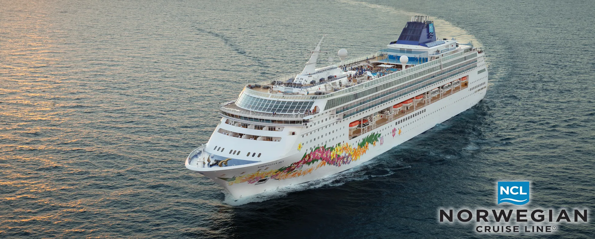 Norwegian Cruise Line ship sailing on ocean with colorful floral design