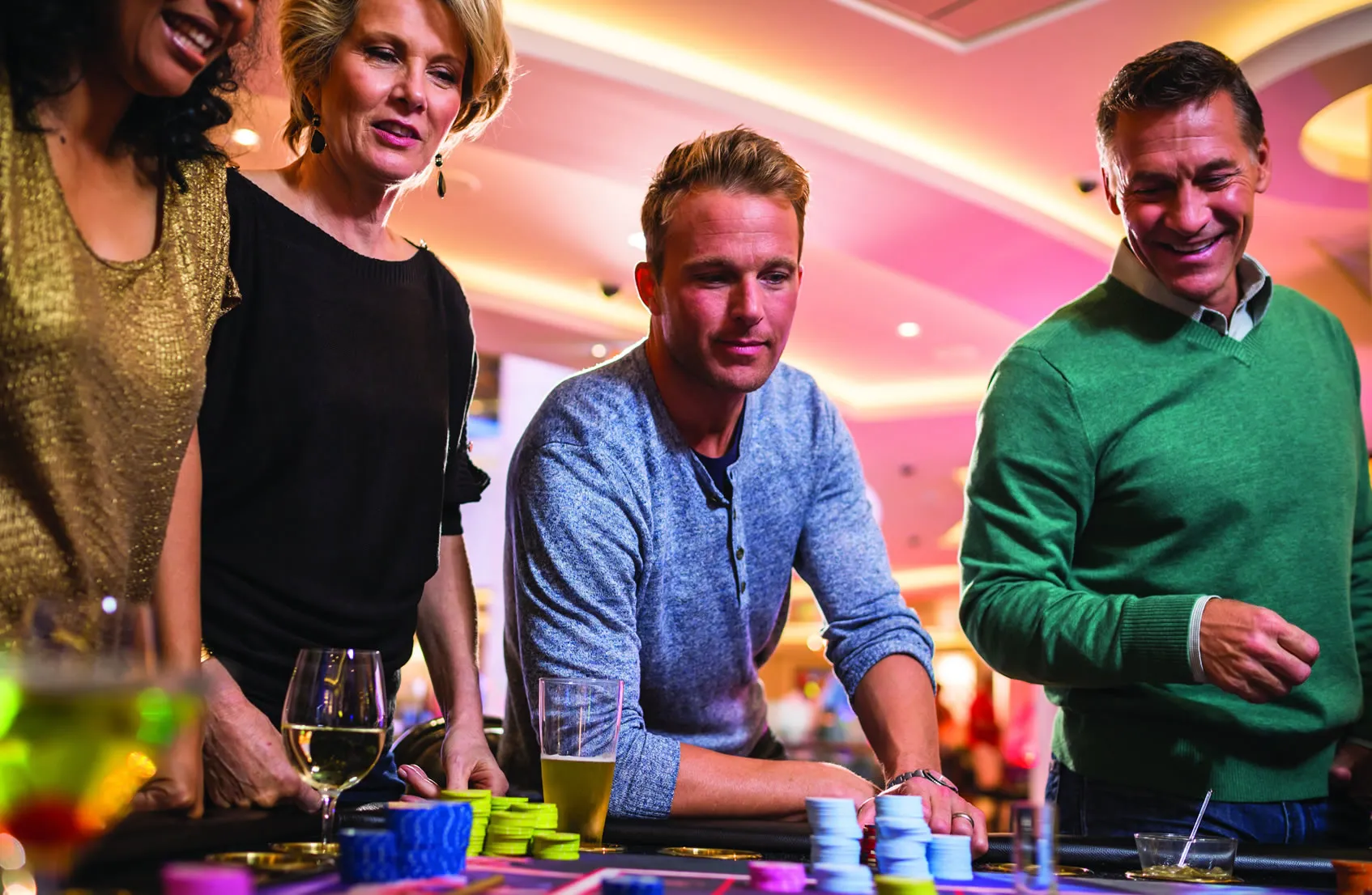 Friends enjoying drinks and gambling at a colorful casino table