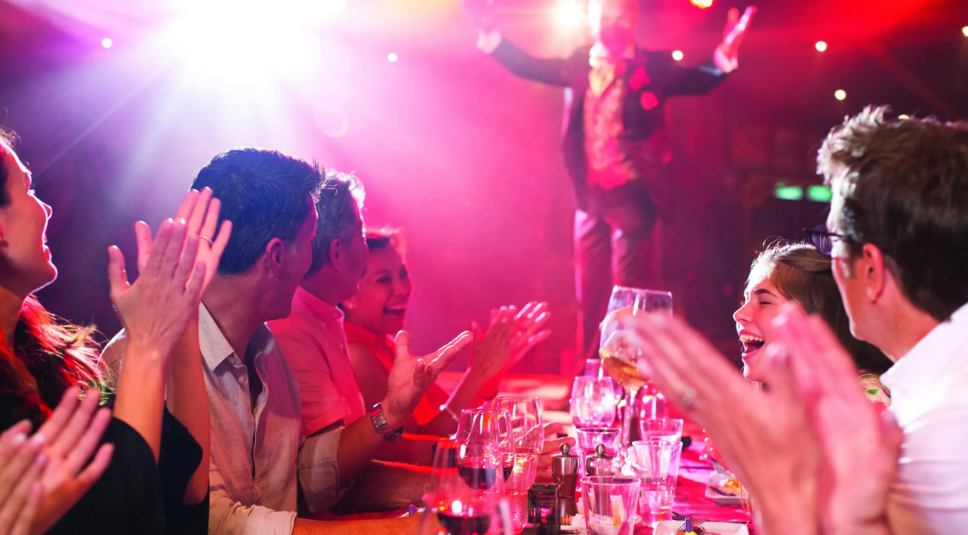 Excited group clapping and enjoying drinks at a vibrant party or event