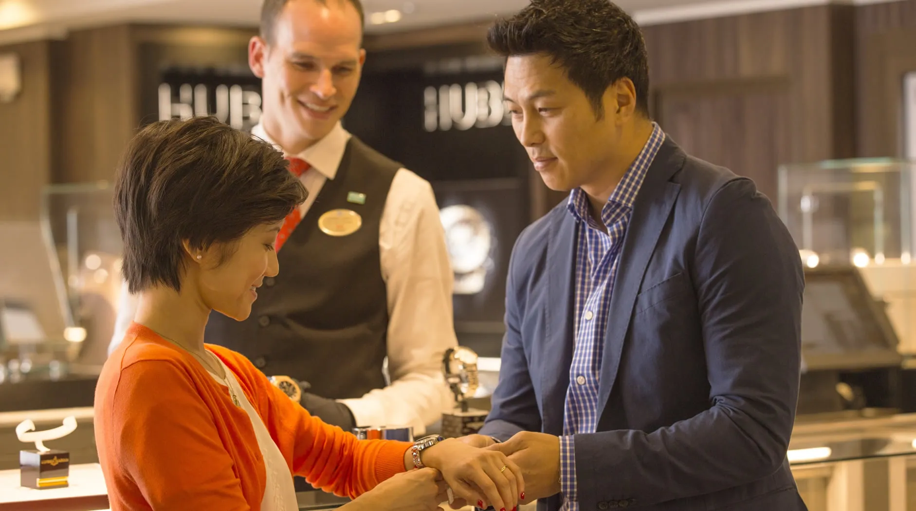 Customer trying on watch with salesperson at luxury jewelry store