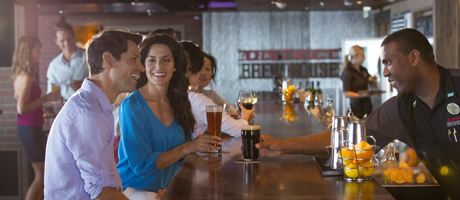 Friends enjoying craft beer at District Brew Line bar with bartender