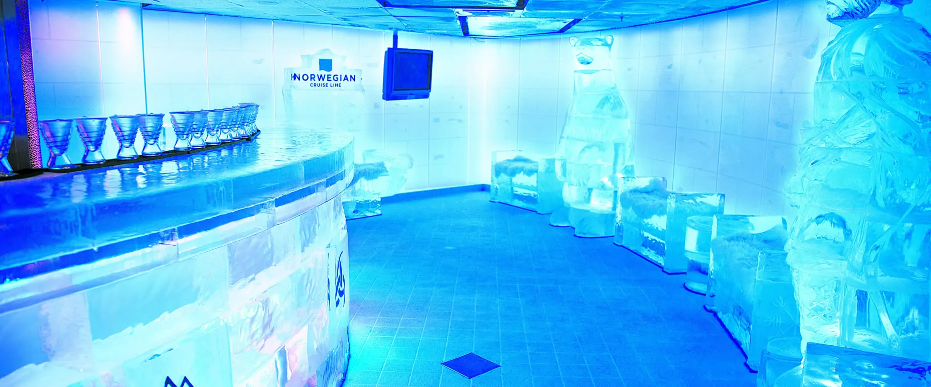 Norwegian Cruise Line's ice bar with blue-lit frozen interior and glassware