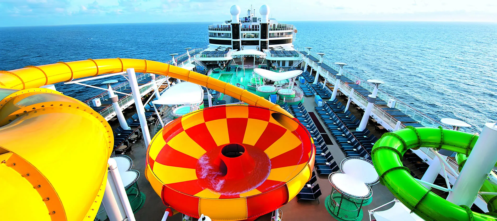 Colorful water slides on a cruise ship deck overlooking the ocean