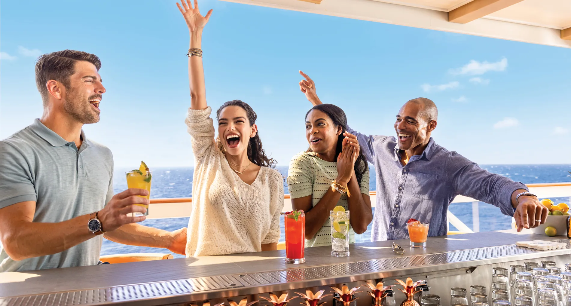 Friends enjoying cocktails and laughing together on a cruise ship deck