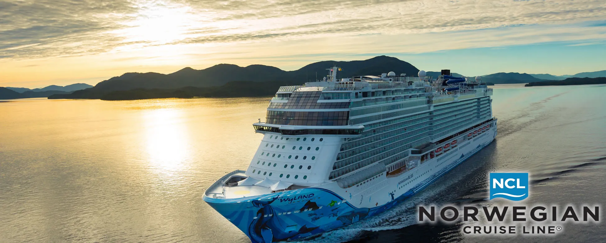 Norwegian Cruise Line ship sailing at sunset with mountains in background