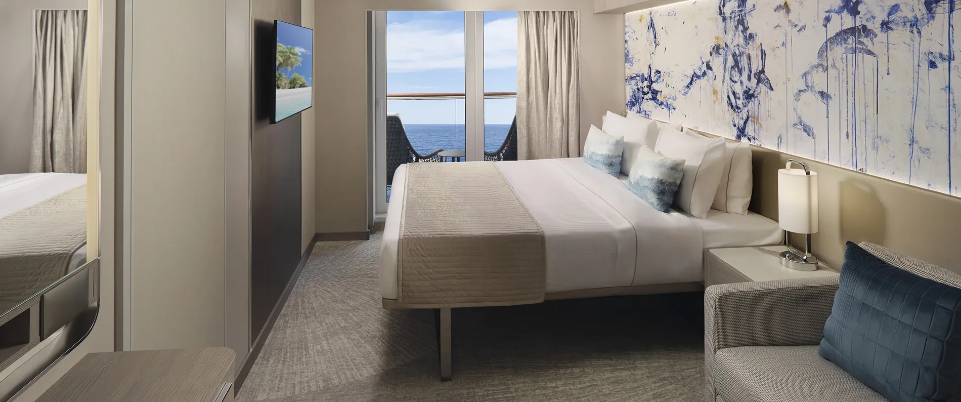 Luxury cruise ship cabin with ocean view, white bed, and blue artwork
