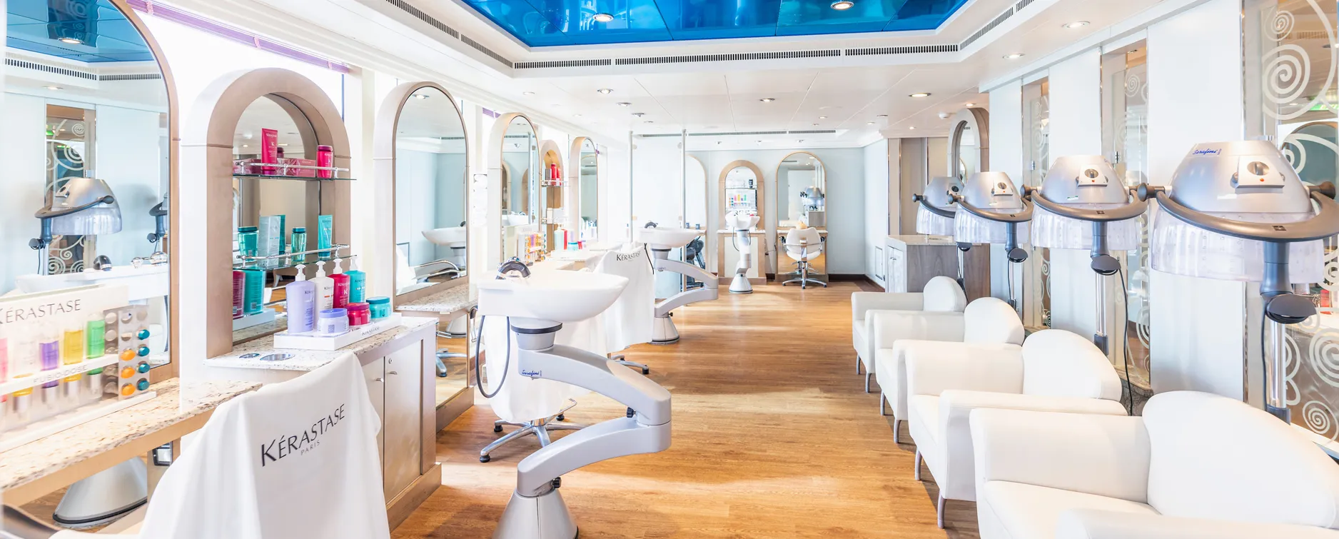Modern, clean hair salon with white chairs and Kerastase hair products