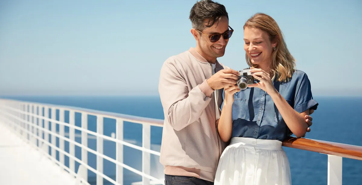 Couple taking photos together on cruise ship deck with ocean view